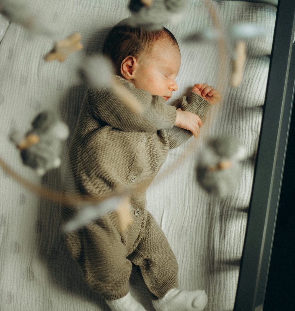 Neonato che dorme sereno nella culla — consulenza del sonno infantile online